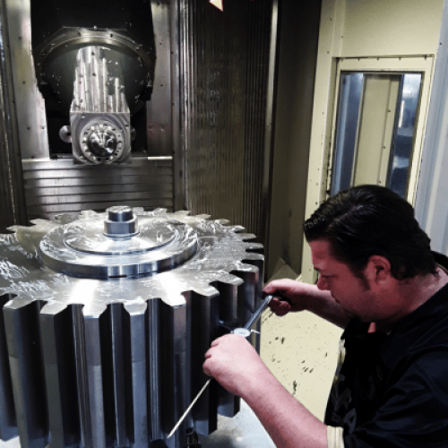 A man repairing a large gear, alternative