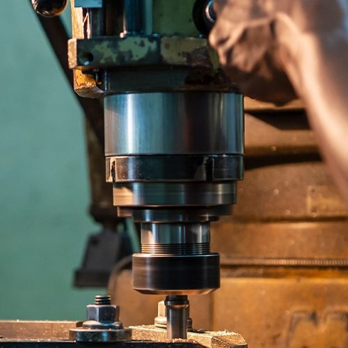 A person using a manual milling machine