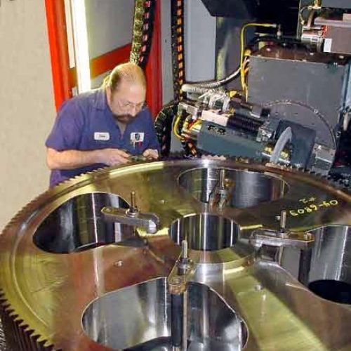 A man repairing a large gear