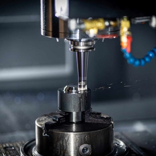 A vertical CNC machine working on a piece of metal